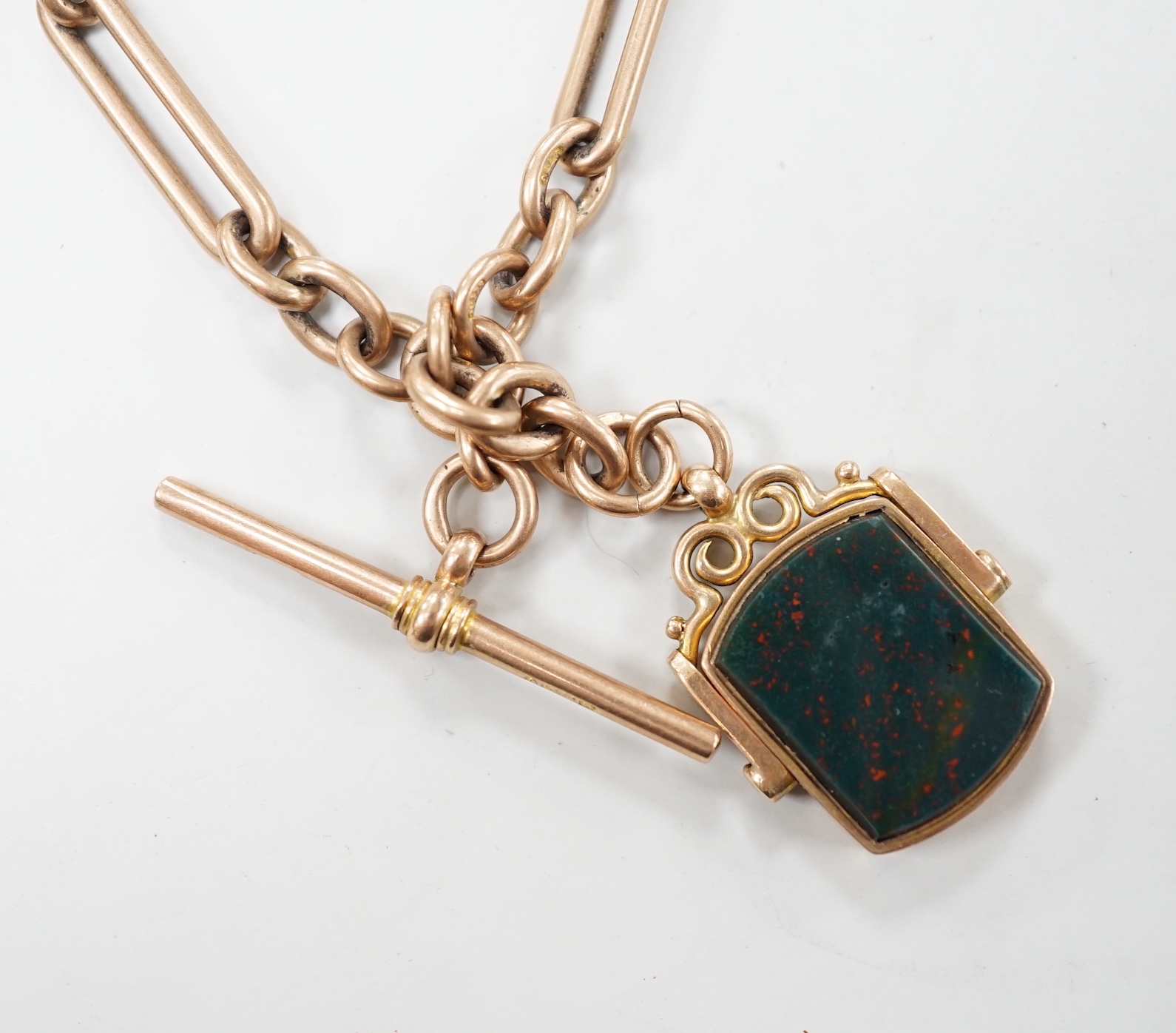 An Edwardian 9ct gold albert, hung with a bloodstone set swivelling fob, 38cm, gross weight 51.1 grams.
